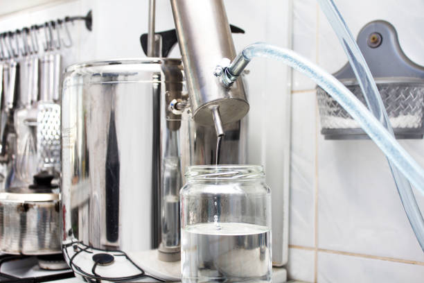 istock Silver distillation machine is standing on the burner in the kitchen. 1128324416