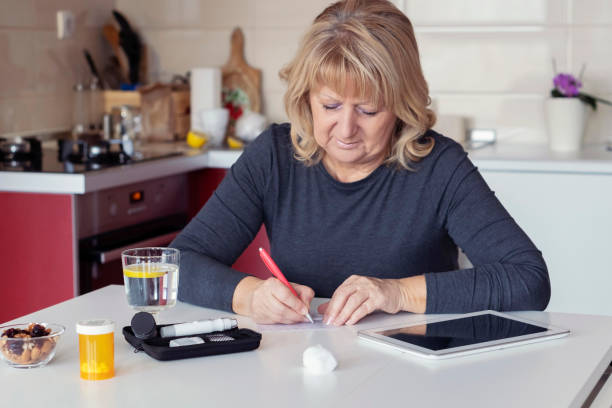 istock Senior  Woman Doing Blood Sugar Test at home 1128324539