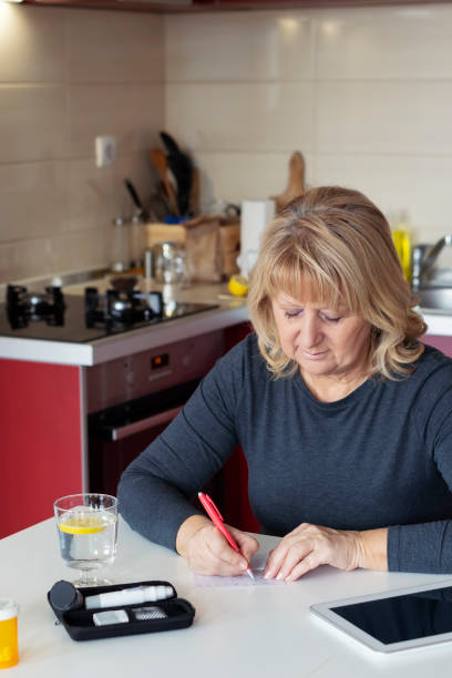 istock Senior  Woman Doing Blood Sugar Test at home 1128324593
