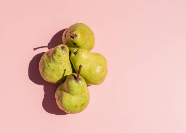 istock Green pears on pink background from above 1128326214