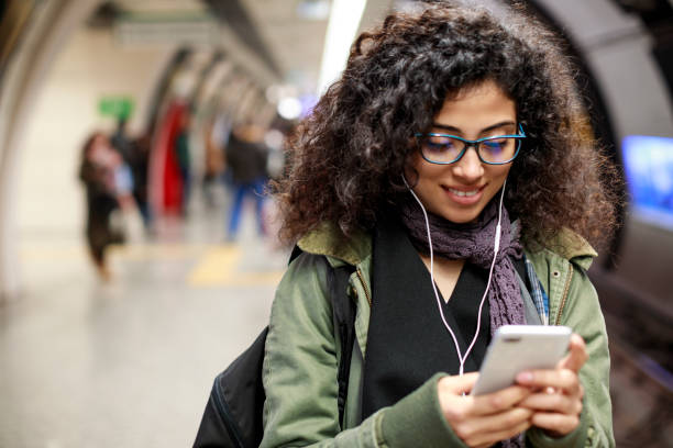istock Young woman using mobile phone in the subway station 1128326950