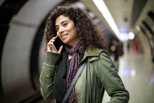 istock Young woman talking on the cell phone at subway station 1128326953