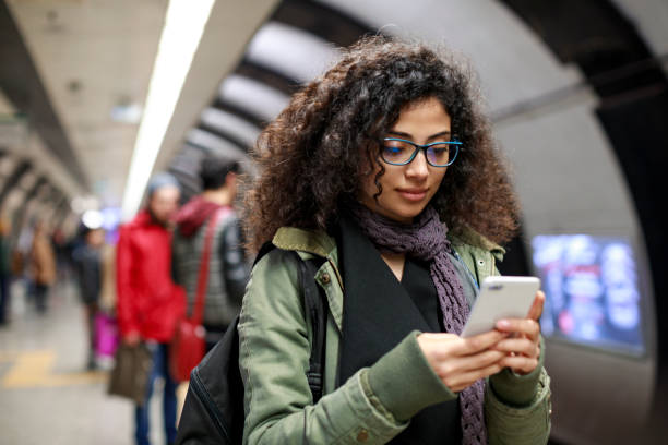 istock Young female commuter using mobile phone in the subway station 1128327079