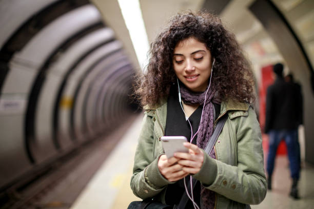 istock Young female commuter using mobile phone in the subway station 1128327162