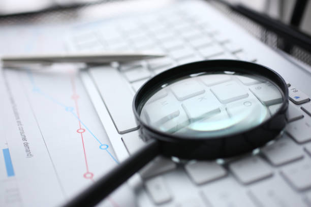 istock Magnifying glass lies on white keyboard on 1128343845