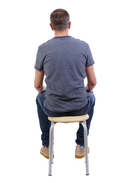 istock Back view of a man sitting on a chair. 1128345819