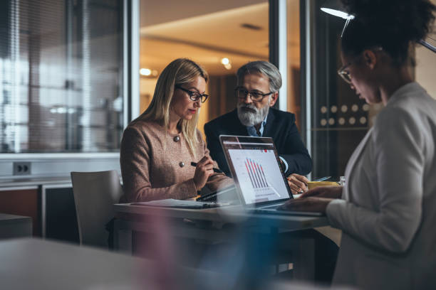 istock Working late with business colleague  in office 1128346185