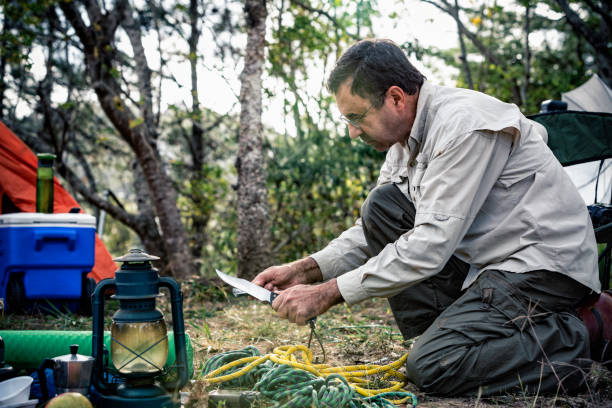 istock Man sharpening knife outdoors in the wilderness 1128359168