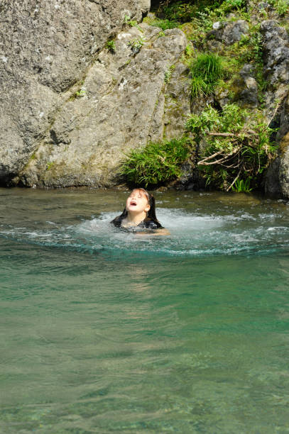 istock Beautiful mixed race girl (brazilian / japanese) having fun in a river. 1128371358