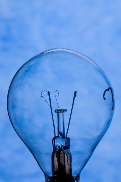 istock Burnt light bulb on blue background close up 1128380864