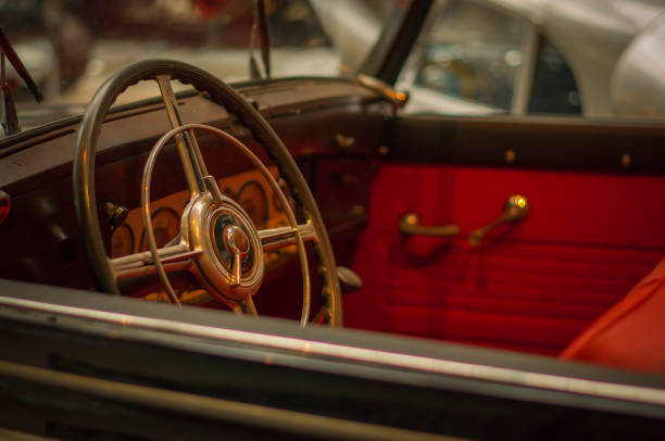 istock Old retro car steering wheel, red interior. 1128387087