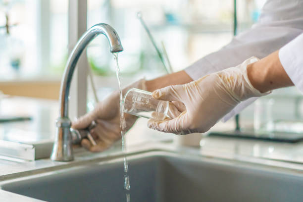 scientist wash beaker from poisonous acid after experiments b - investigates imagens e fotografias de stock