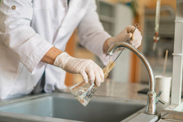 istock scientist wash beaker from poisonous acid after experiments b 1128387165