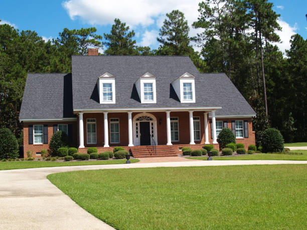 Two Story Brick Residential Home Thomasville, Georgia, USA - September 25, 2009:  Two story brick residential home with large front porch and side entrance garage. dormer stock pictures, royalty-free photos & images