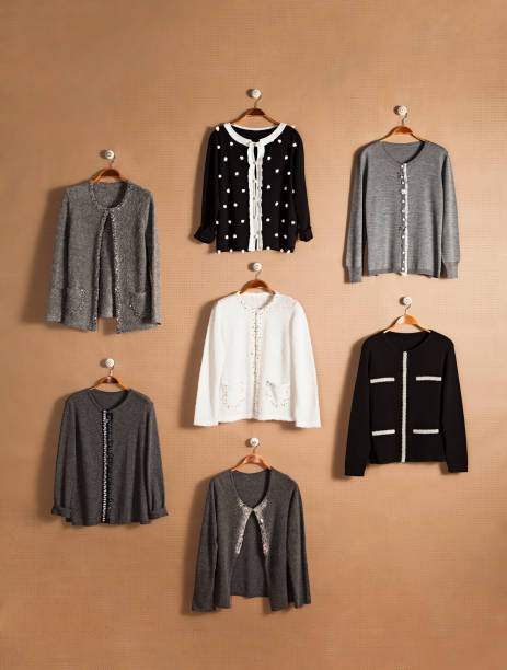 istock Fashionable cardigans on hanger isolated on beige background 1128389580