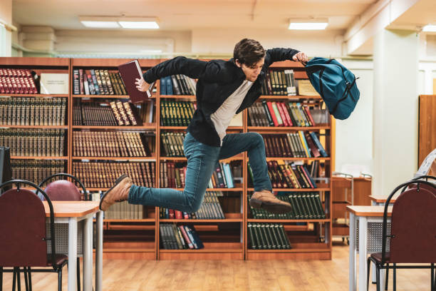 istock happy student jumping with books and backpack b 1128391481