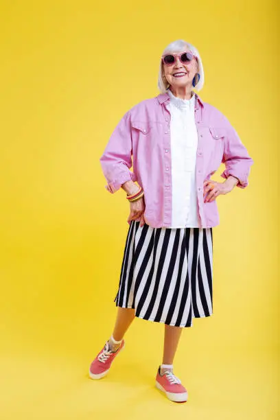 Photo of Cheerful retired woman loving bright colors smiling broadly