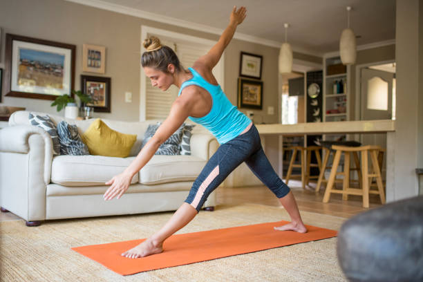 istock Determined sporty woman practicing yoga at home 1128394464