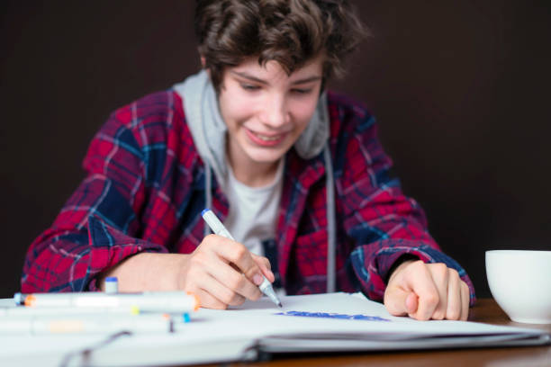 istock closeup male sitting at a table and write in notebook and prepare for the test b 1128395617