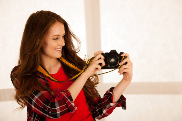 istock attractive beautiful woman holding a retro camera 1128396437