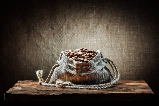 burlap bag of coffee beans on vintage wood