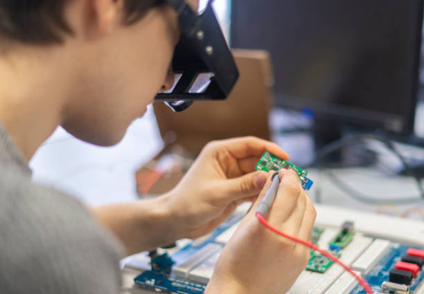 istock young man in special zoom glasses work with silicon electronic chip b 1128397343