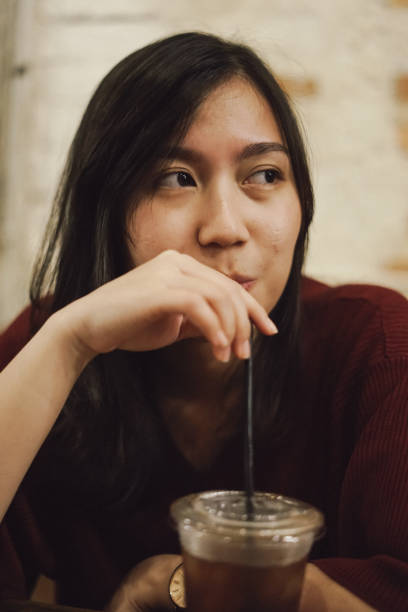 istock millennial girl drinking ice tea 1128397429