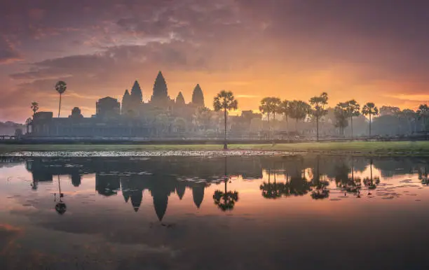 Sunrise view of popular tourist attraction ancient temple complex Angkor Wat with reflected in lake Siem Reap, Cambodia