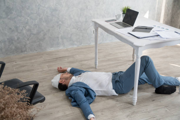 istock Sick businessman sleeping on floor while using laptop to work hard at office 1128403671
