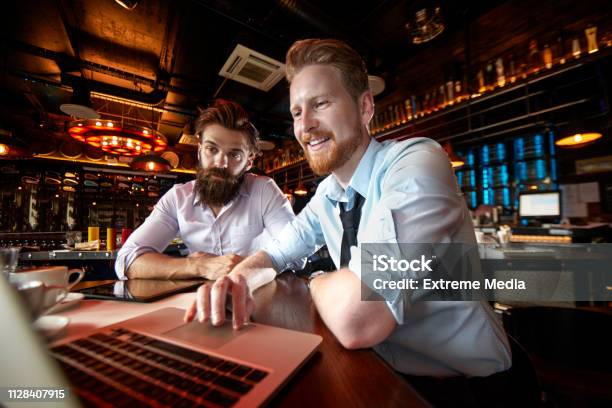 Zwei Geschäftsleute Arbeiten Unterwegs Auf Einem Laptop In Einem Café Zusammen Stockfoto und mehr Bilder von Lokal