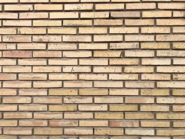 istock Vintage and old yellow brick wall with white joints texture background 1128412618