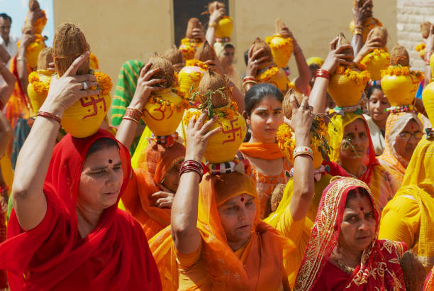 코코넛과 냄비를 들고 노란색과 빨간색 사리를 입고 rajasthani 여자의 군중 bikaner, 인도에서 종교적 행렬에 참여 한다. - lr pan 뉴스 사진 이미지