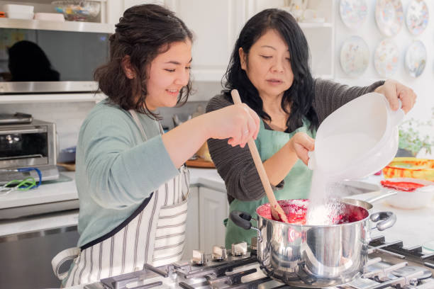 istock Mother and Daughter Making Berry Jam Together in Home Kitchen 1128416195