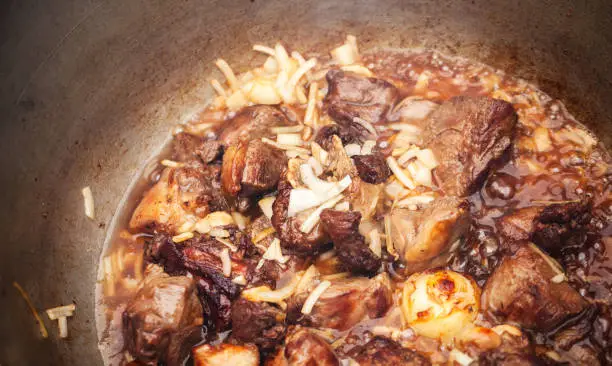 Photo of Lamb and vegetables boiling in a cauldron