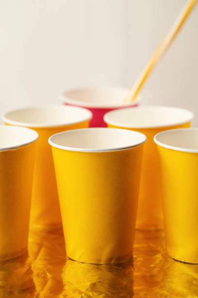 istock Disposable paper cups, yellow and pink,  straws. Close up 1128429798