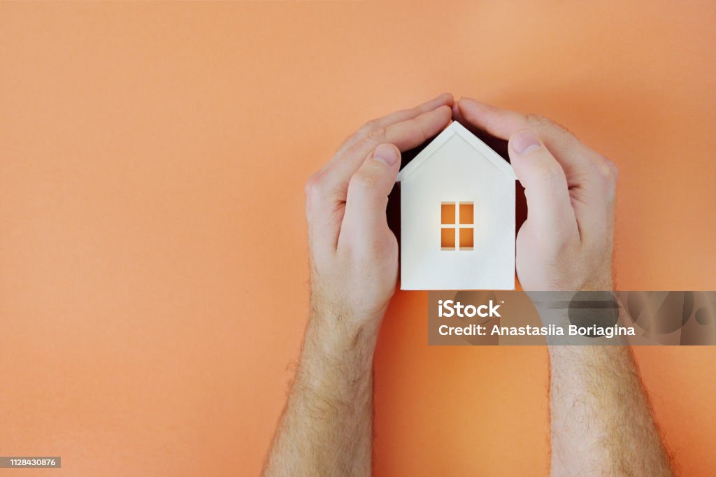 Male hand with model house. Flat lay style Male hand with model house. Flat lay style. Copy space Living coral Adult Stock Photo