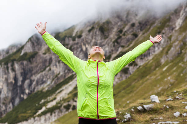 istock Woman celebrating in the mountains 1128440608
