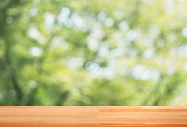 istock Empty seamless wooden table template top on nature green blurred background for decorated montage of your product on table. 1128442231