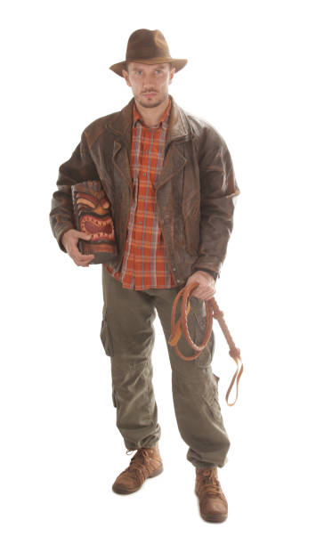 istock Adventurer explorer is holding whip and ancient wooden idol 1128444121