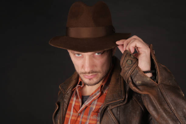 istock Adventurer explorer is touching his fedora hat 1128444135