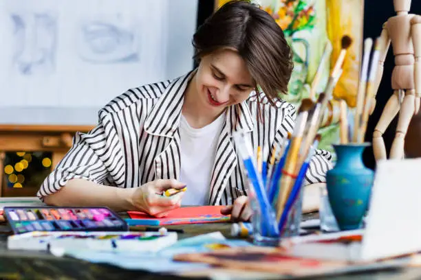 Photo of Young successful artist in art workshop studio