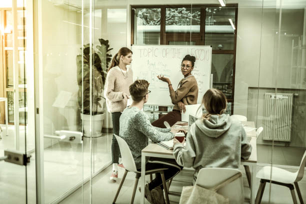 istock Teacher wearing glasses explaining new material to her students 1128444416