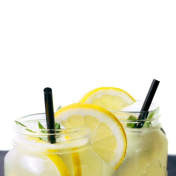 istock Refreshing lemonade drink with lemon slice and mint in the jar on dark table and white background 1128444746