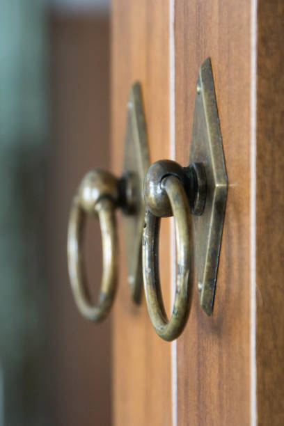 istock Metal handle knocker on wooden door, window 1128445436