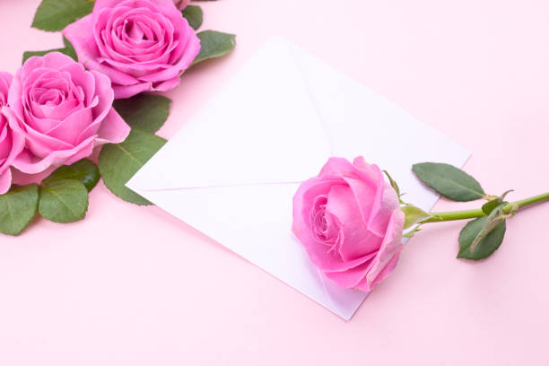 istock roses and envelope on a light background. Bouquet and letter as a gift in the concept of Valentine's Day and Women's Day. Free space for text. 1128445766