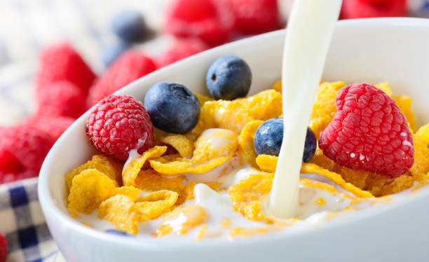 istock Pouring milk into bowl of Corn Flakes with berries 1128445965