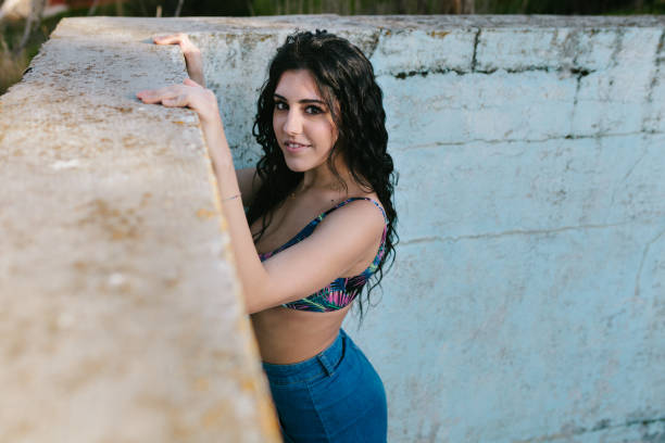 istock Smiling young brunette woman with bikini in an old empty pool 1128446806