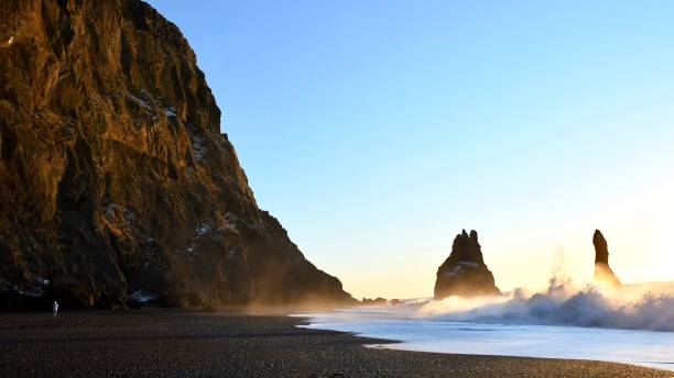 istock the sunrise light caresses the waves running to te coastline 1128450943
