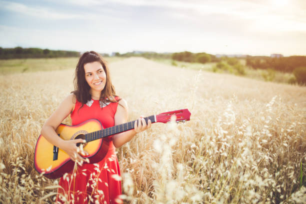 istock Woman plays guitar in a wheat field. 1128451123