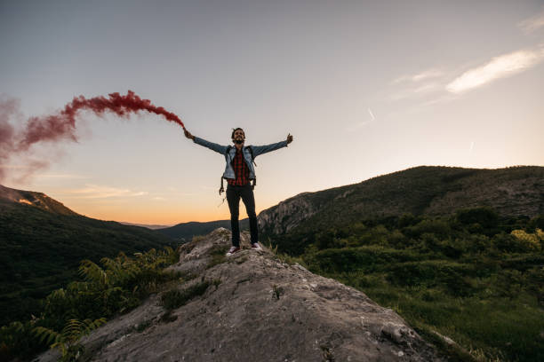 istock Hiker holding a torch on mountain peak 1128455235